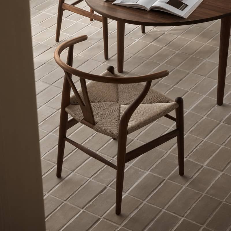 Ein Stuhl, der aus dunklem, geschwungenem Holz und einem hellen Geflecht besteht